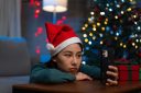 Woman wearing a Santa hat talking with her friend by video call