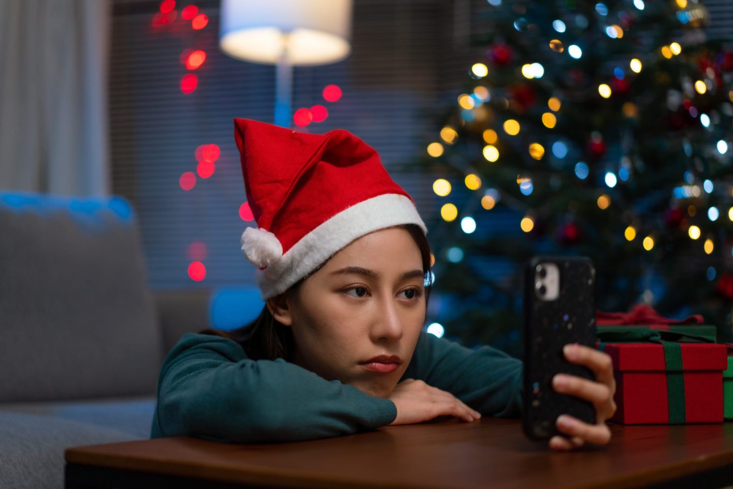 Woman wearing a Santa hat talking with her friend by video call