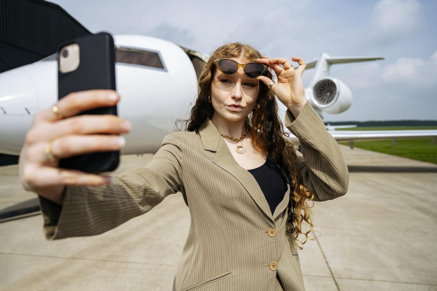 Young rich woman in front of plane
