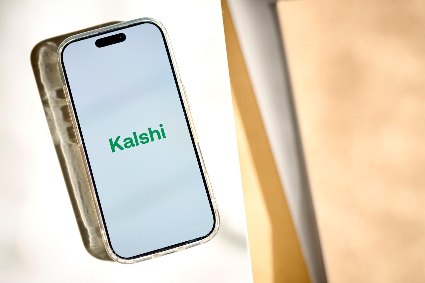 A phone screen showing the Kalshi logo