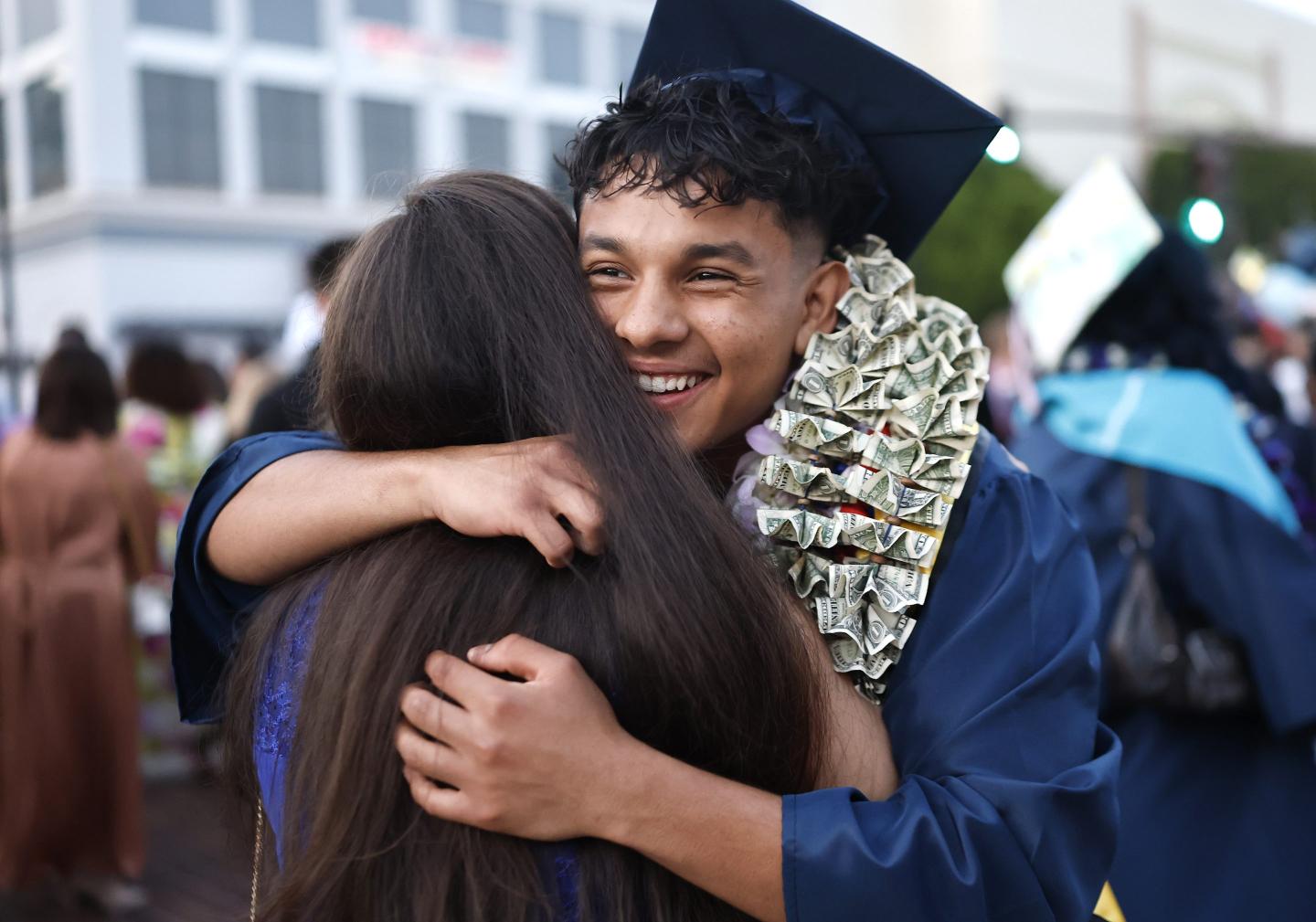 Every year, a billionaire CEO doles out $1,000 checks to local college grads—with a catch: They have to give half the money to charity