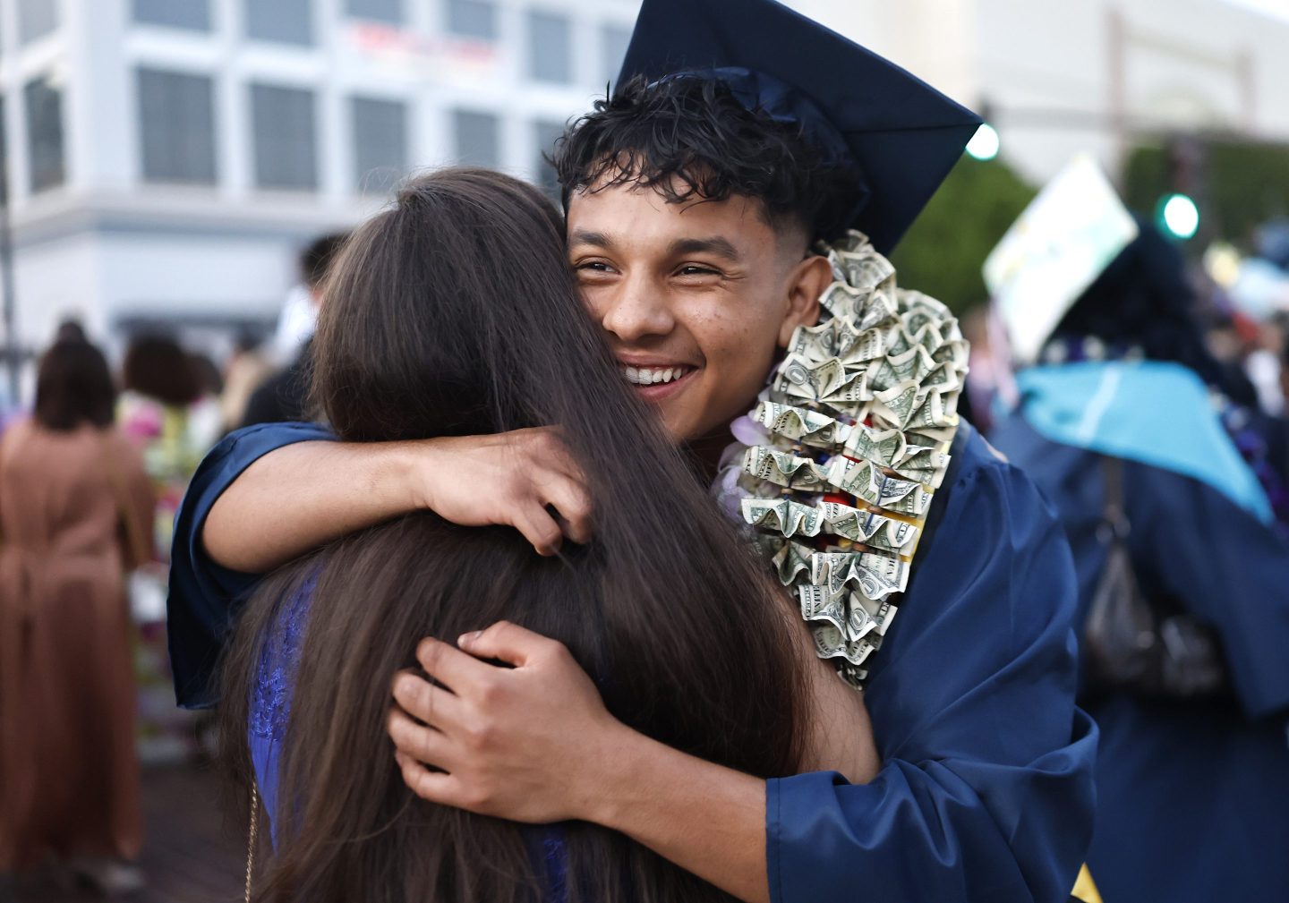 PASADENA, CALIFORNIA - JUNE 05: A class of 2025 graduating senior is hugged following the Thurgood Marshall Secondary School graduation ceremony on June 5, 2025 in Pasadena, California. 91 students at the Pasadena school lost their homes in the Eaton Fire, the second-most destructive wildfire in California history. (Photo by Mario Tama/Getty Images)