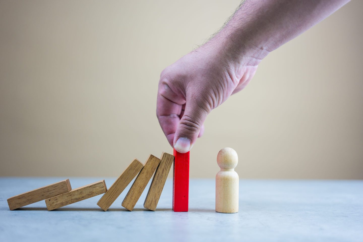 domino pieces falling on a board game piece and almost knocking it over