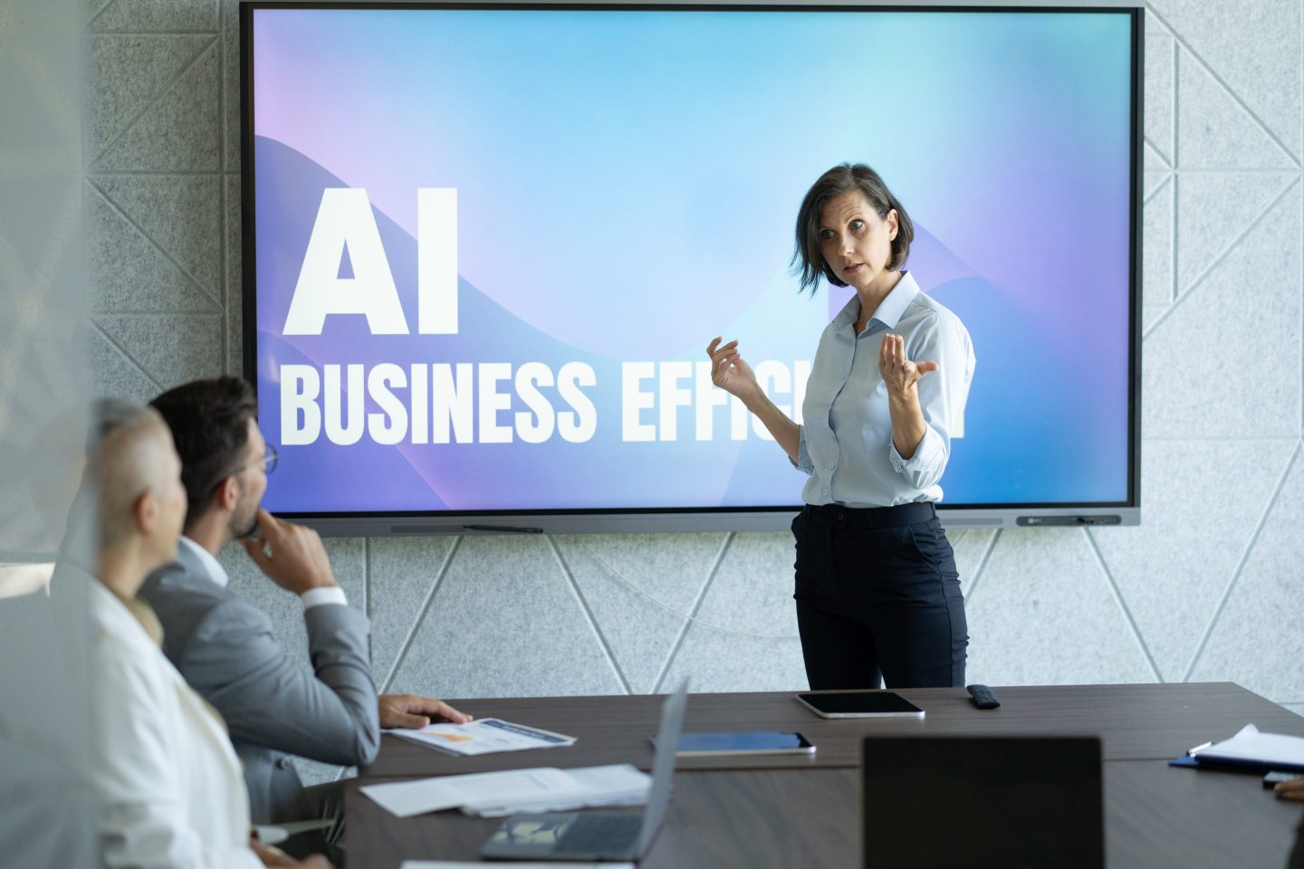 Businesswoman discussing AI business efficiency to her colleagues in a meeting room.