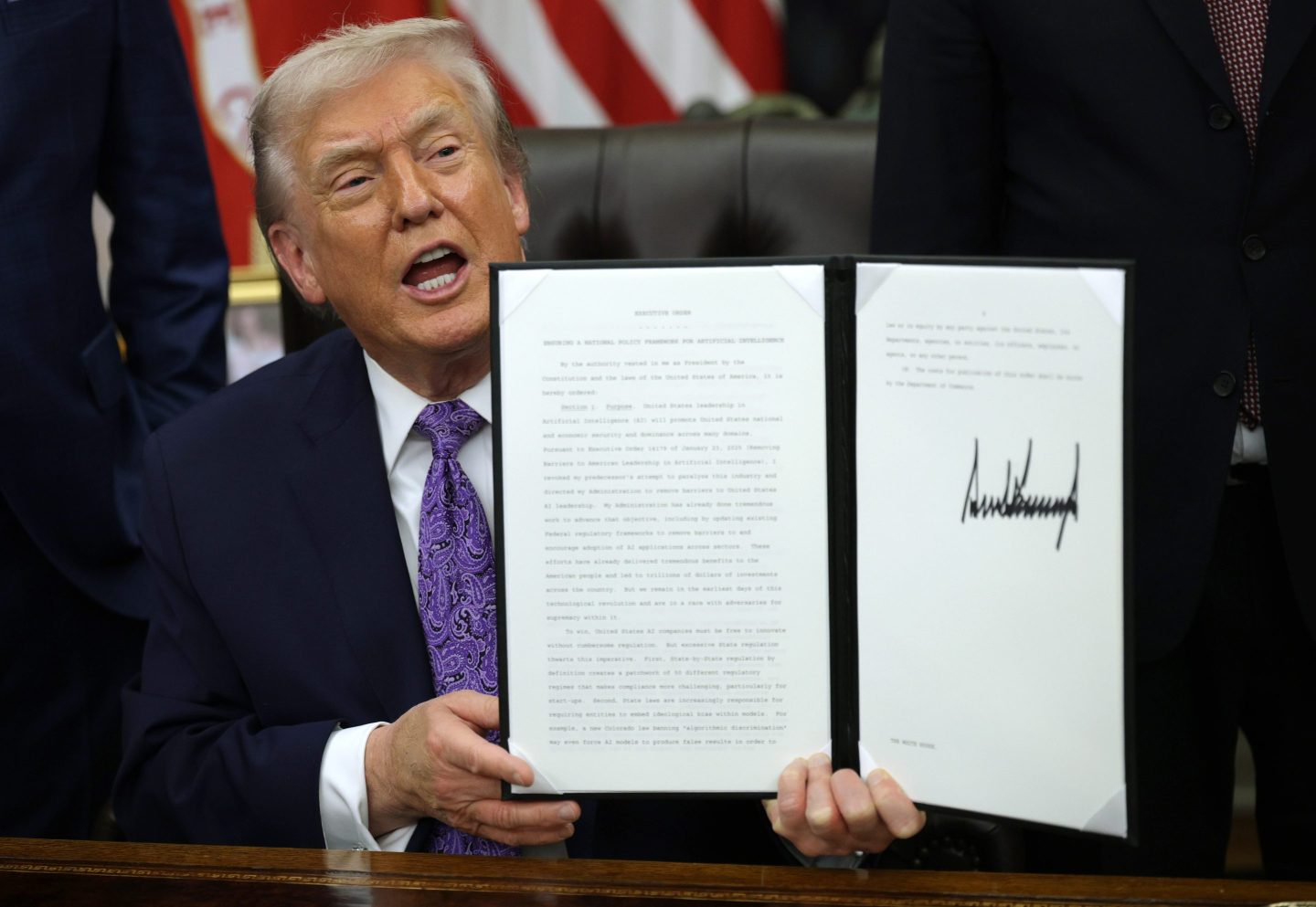 President Donald Trump displays a signed executive order in the Oval Office of the White House on December 11, 2025 in Washington, DC.