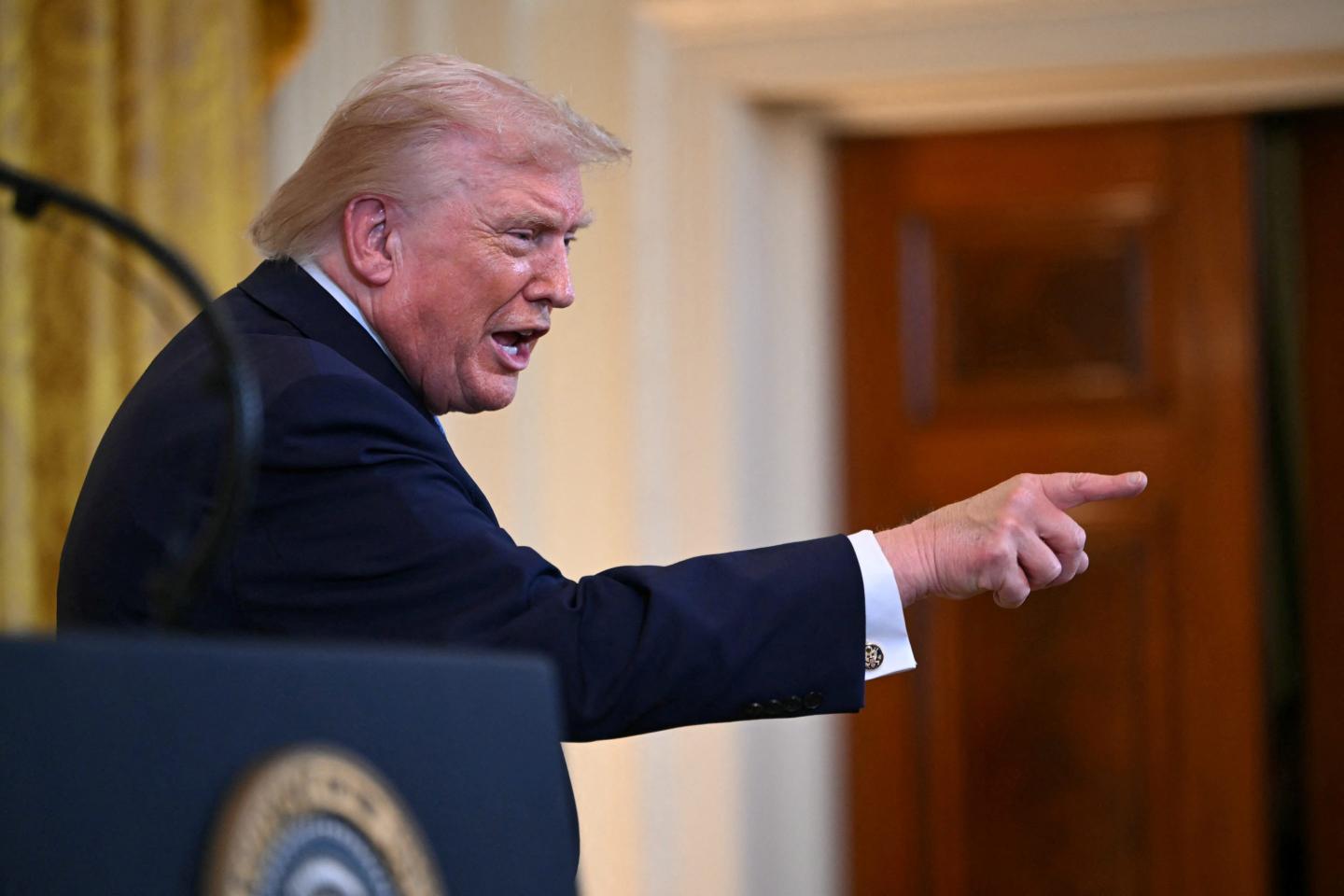 Trump points his finger into the crowd from behind the presidential podium