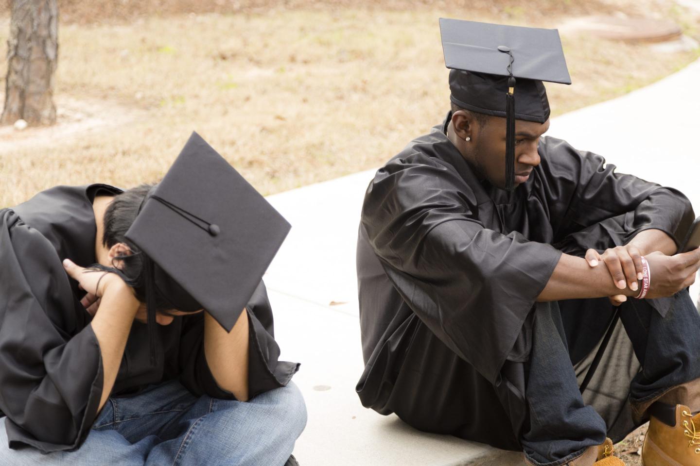 Two college students sit in somber
