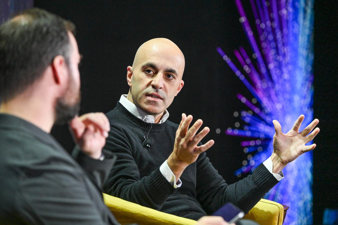 Databricks CEO Ali Ghodsi speaking on stage at a Fortune tech conference.