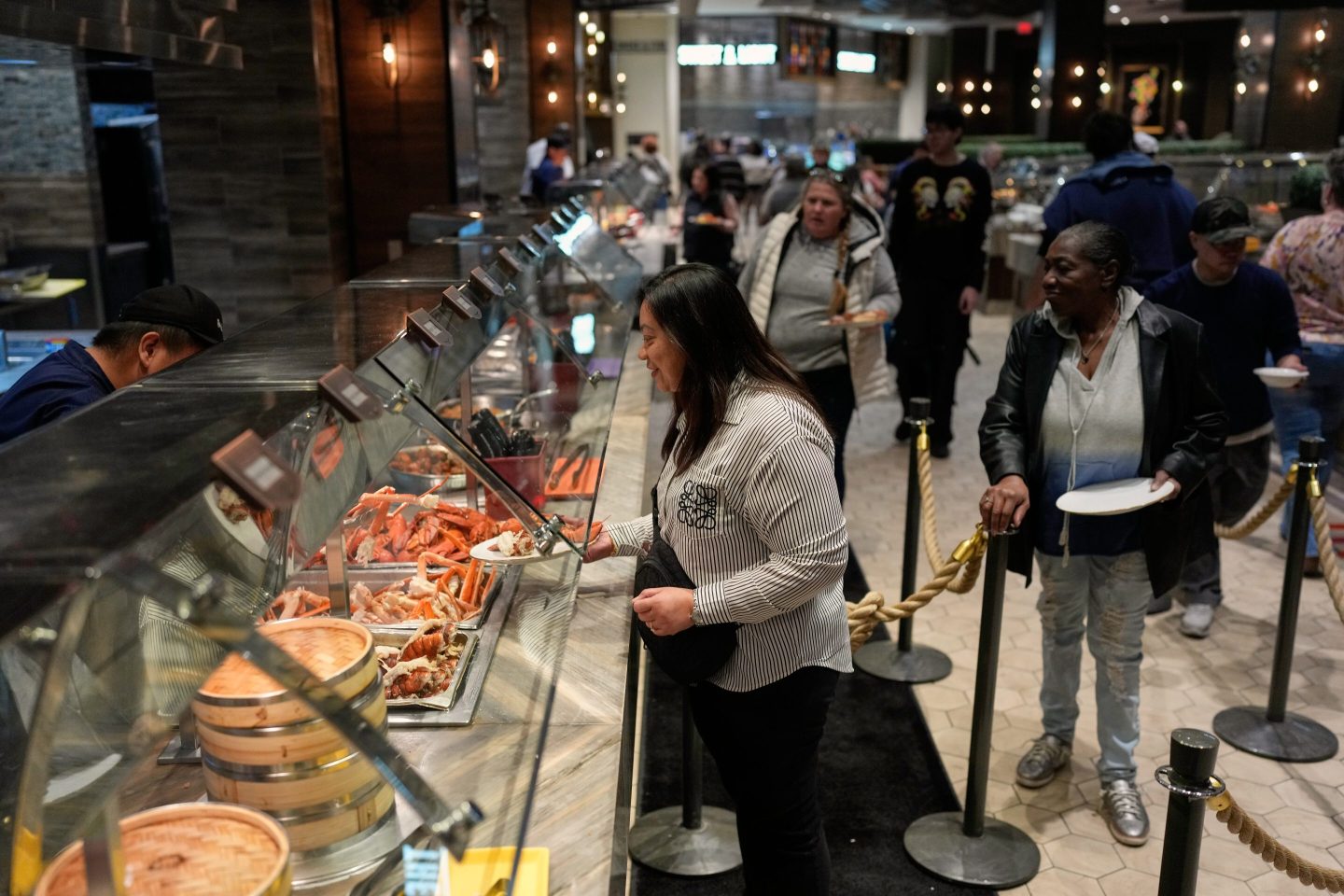People are served food at the A.Y.C.E Buffet in the Palms resort-casino Wednesday, Jan. 28, 2026, in Las Vegas. (AP Photo/John Locher)