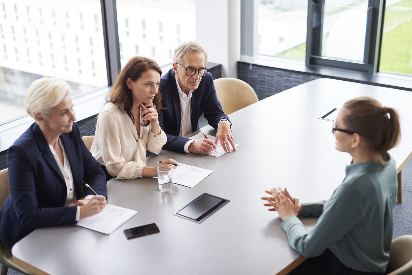 Woman during job interview and three members of management or an HR team.