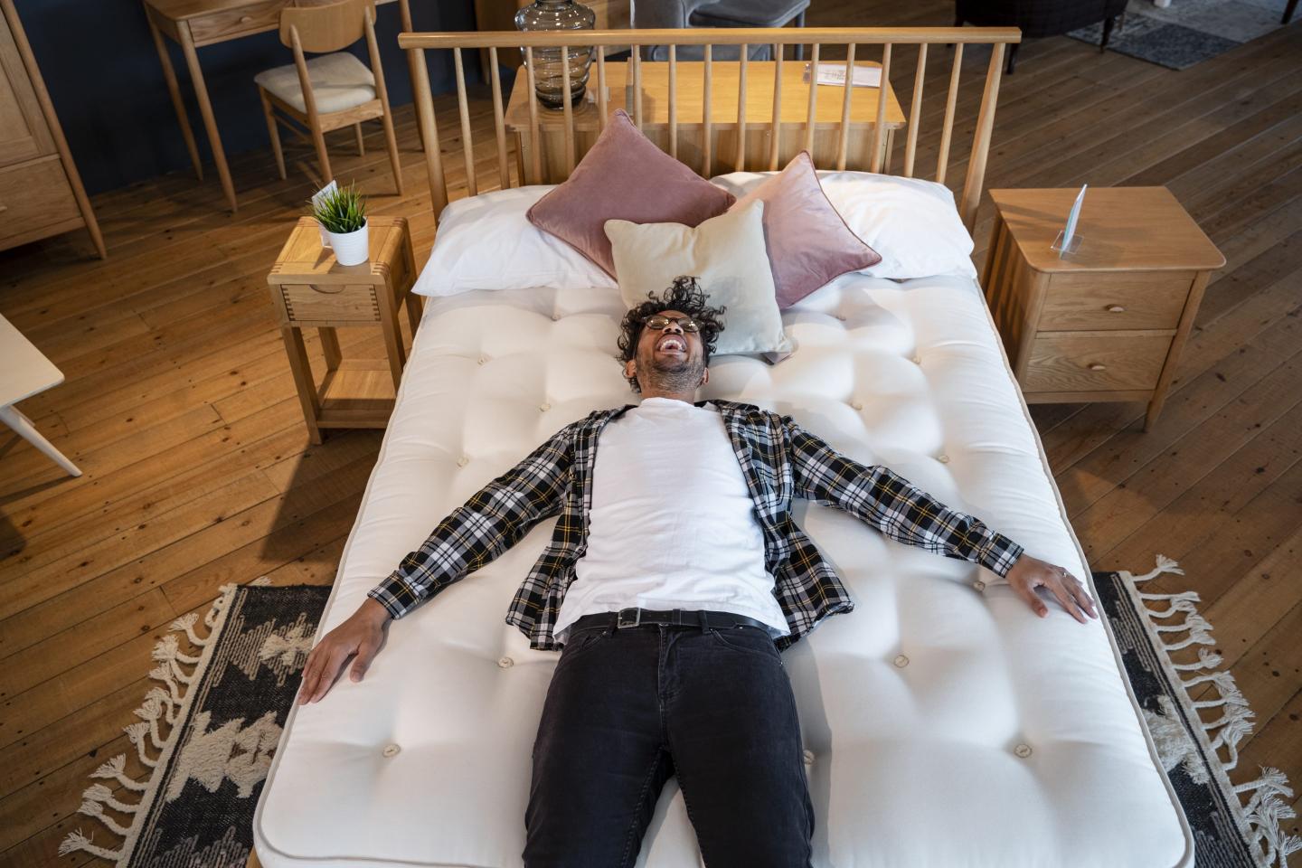A person laying on a bed in a store.