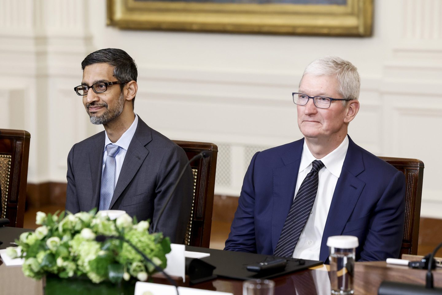 Alphabet and Google CEO Sundar Pichai seated next to Apple CEO Tim Cook at a formal dinner.