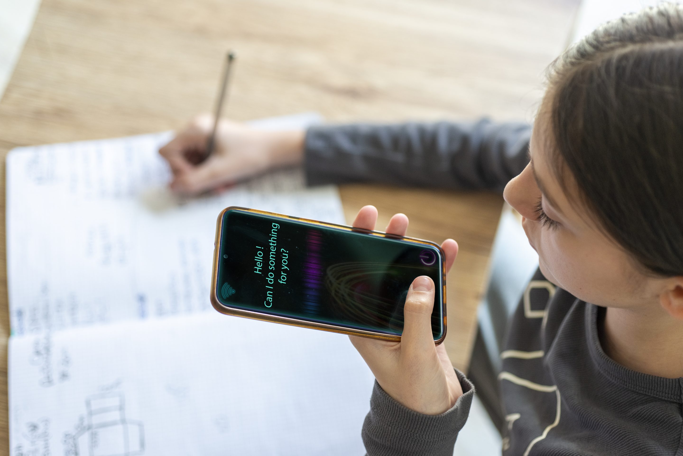 Young girl uses AI virtual assistant to do schoolwork.Concept of Artificial Intelligence and Futuristic technology