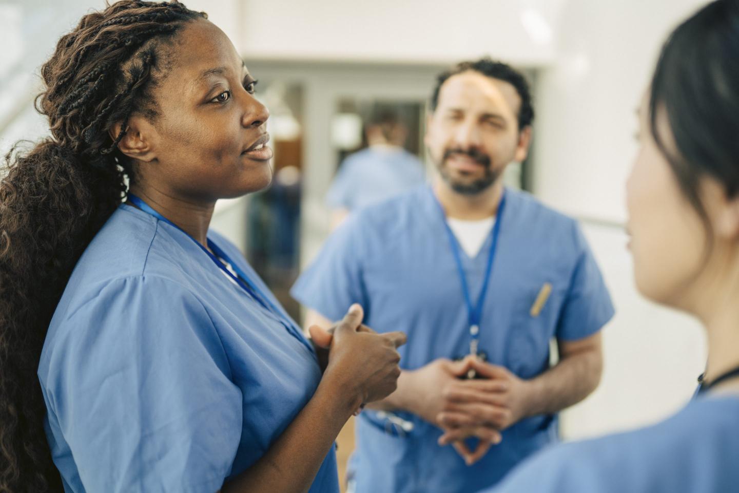 Female nurse communicating with coworker in meeting at hospital