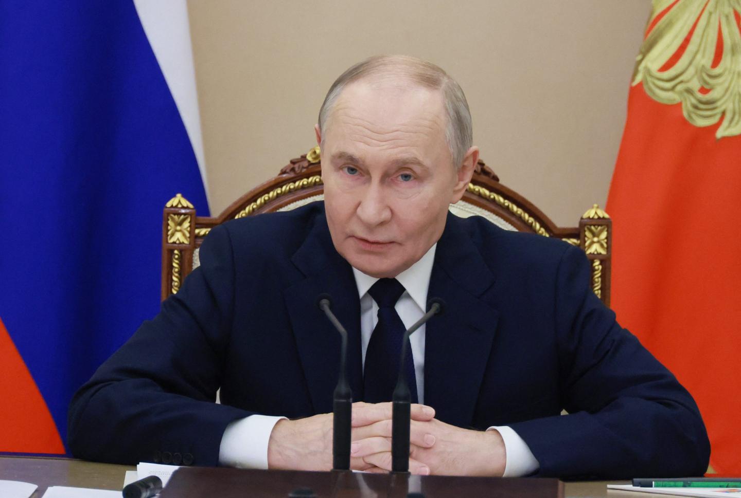 vladimir putin speaks in front of a microphone