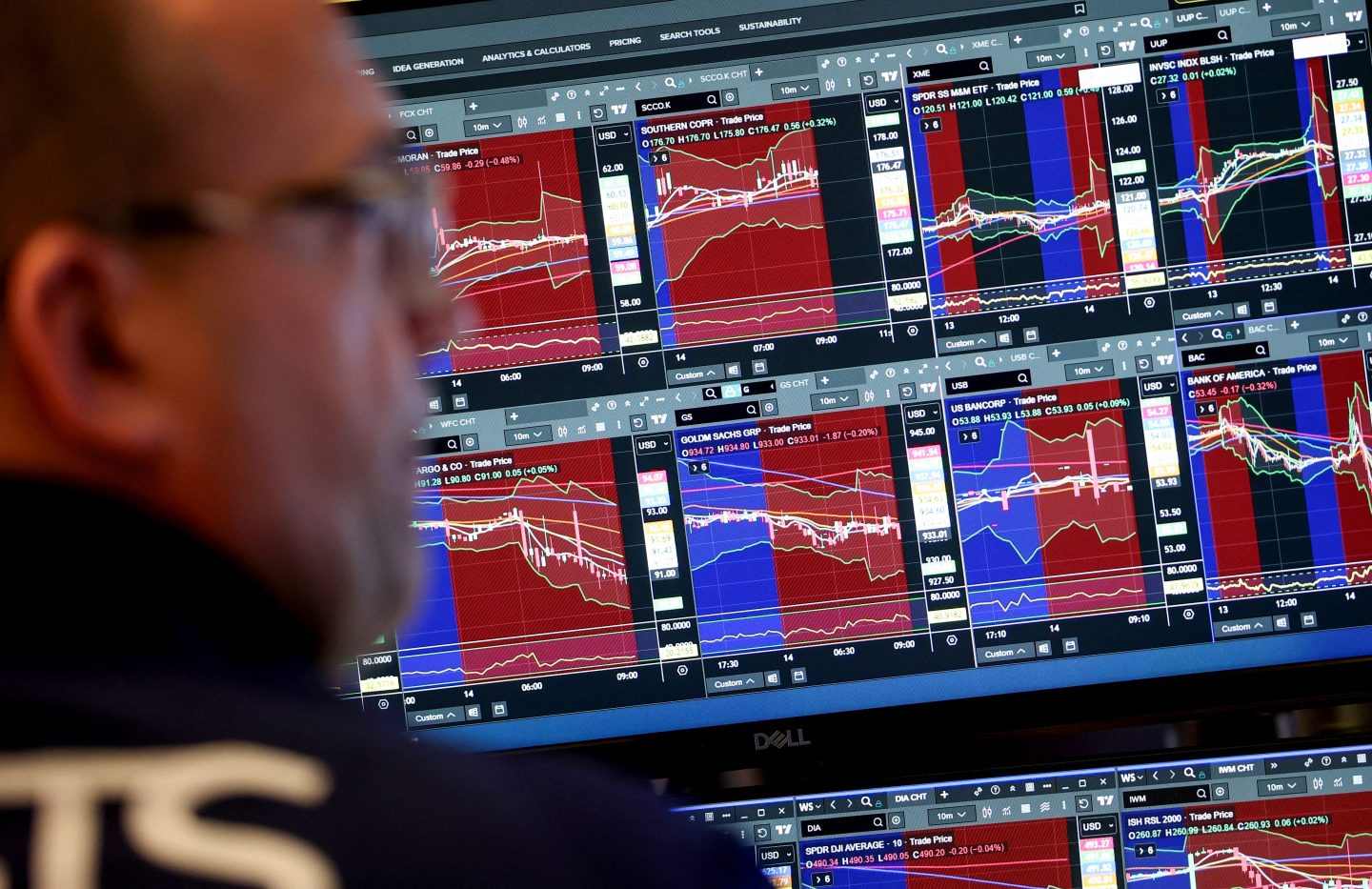A trader works at his desk on the floor of the New York Stock Exchange (NYSE) in New York on January 14, 2026. Wall Street stocks retreated early Wednesday as markets digested solid earnings from large US banks and delayed retail sales data that topped expectations. Geopolitical tensions have been prominent in the early part of 2026 so far, with President Donald Trump threatening Iran over its response to civilian protests and the White House emphasizing its designs on taking over Greenland. (Photo by TIMOTHY A. CLARY / AFP via Getty Images)