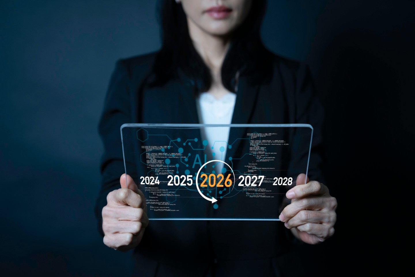 Businesswoman holding futuristic glass tablet with 2026 year and AI interface. Concept of artificial intelligence, digital innovation, future planning, and smart global business strategy.