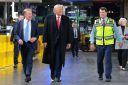 U.S. President Donald Trump (C) walks with Executive chair of Ford Motor Company Bill Ford Jr. (L), and CEO of Ford Motor Company Jim Farley as they tour the Ford River Rouge Complex on January 13, 2026 in Dearborn, Michigan.