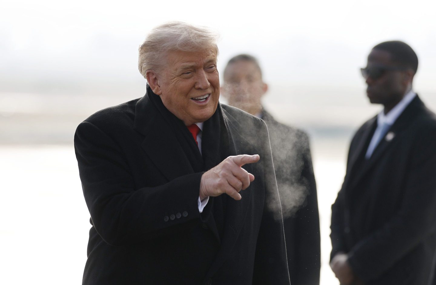 President Donald Trump greets people as he steps off plane in Switzerland