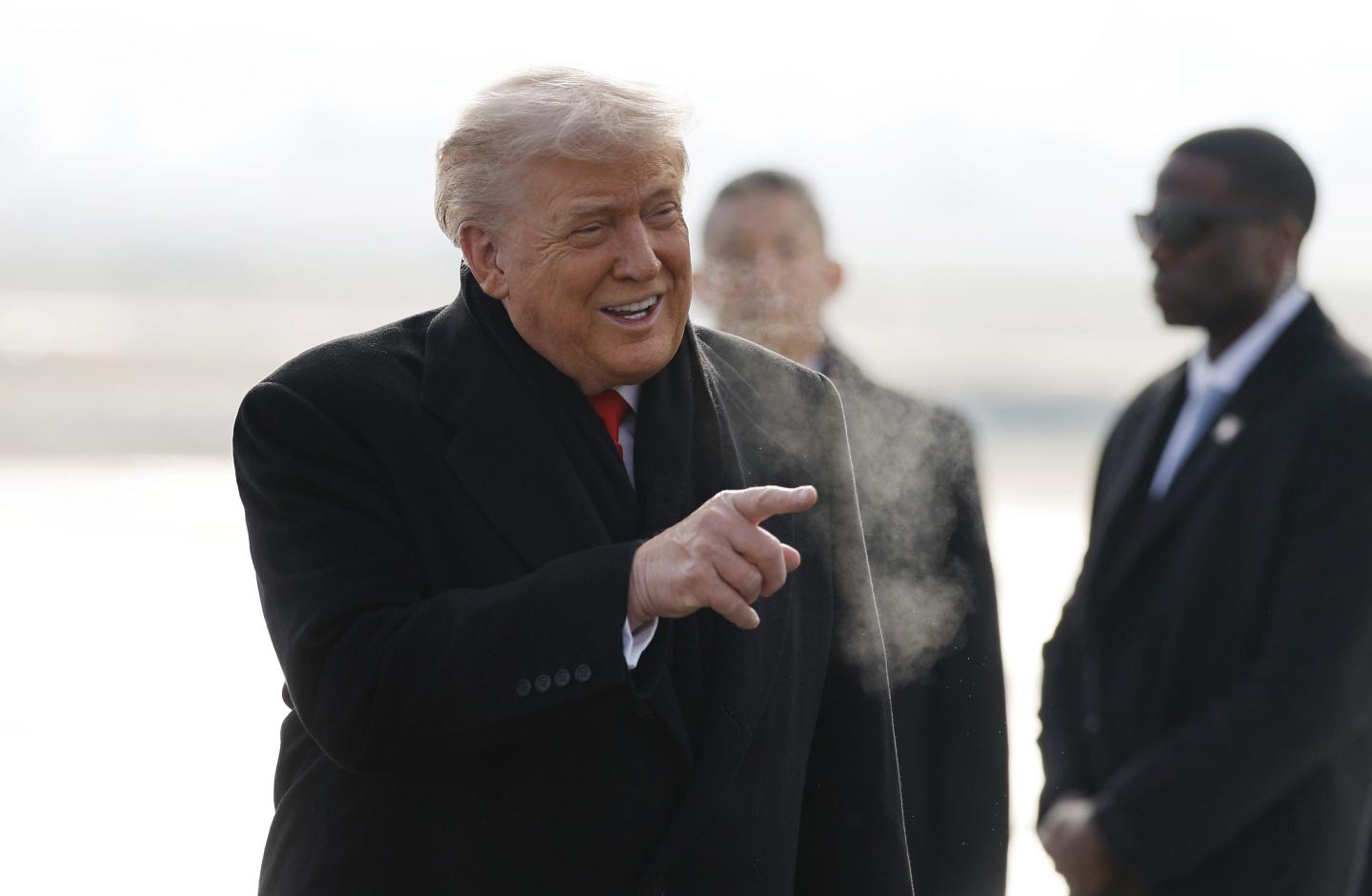 President Donald Trump greets people as he steps off plane in Switzerland