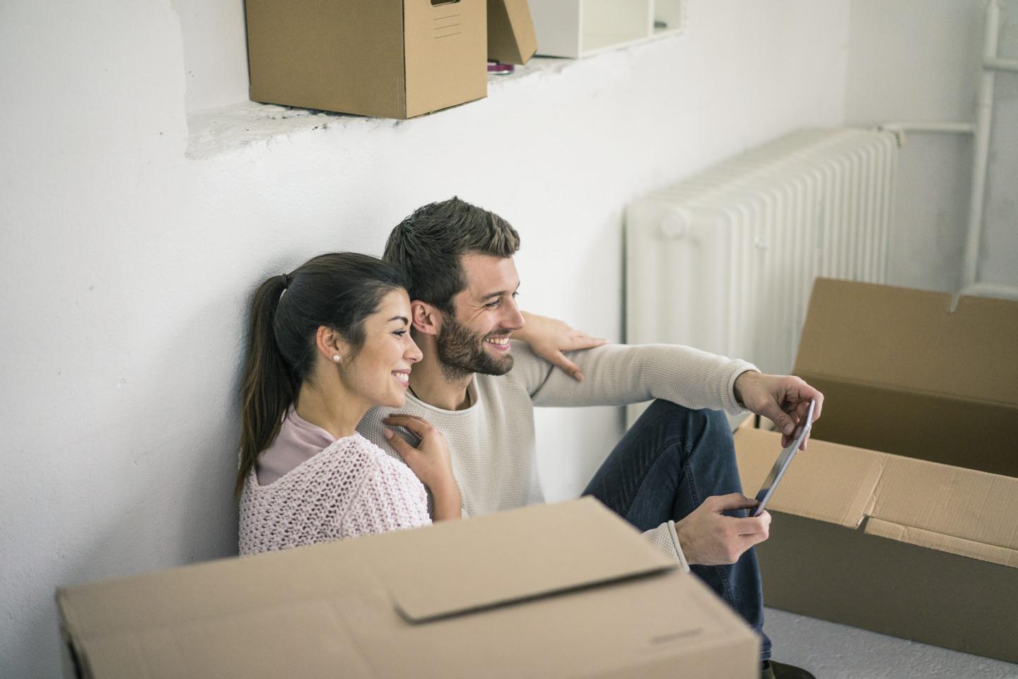 Woman and man sitting surrounded by cardboard boxes