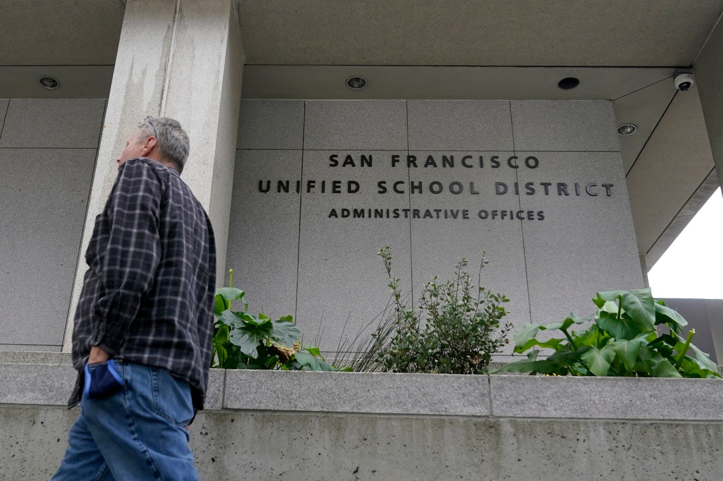 A man walks by the San Francisco Unified School District administrative building.