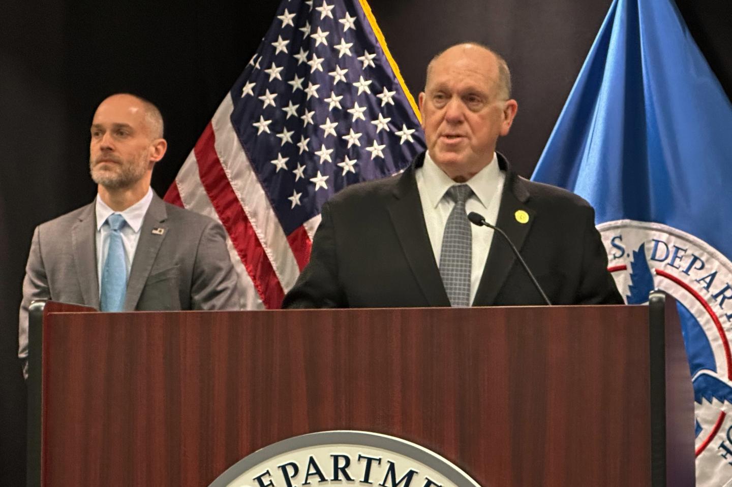 Tom Homan speaks at a podium.