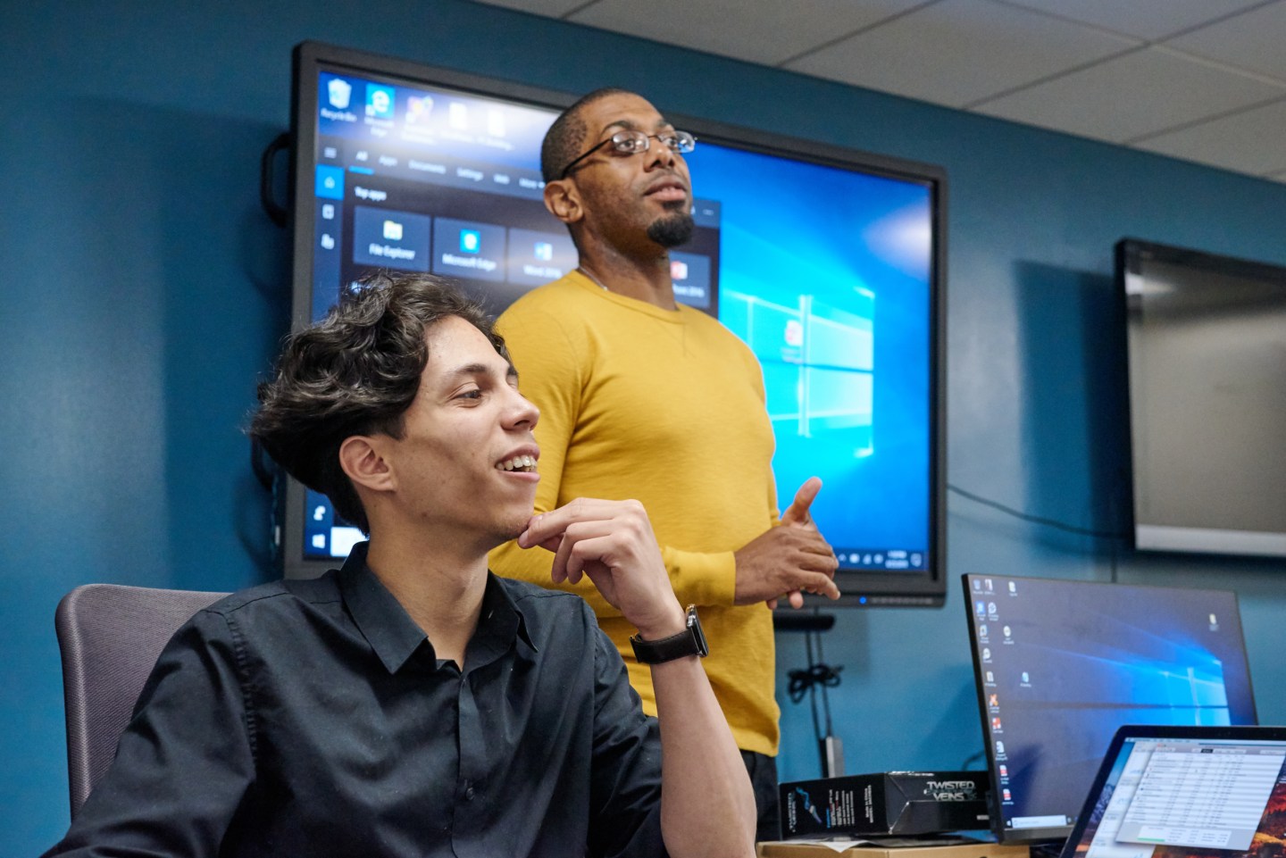 Two young men participate in a meeting.