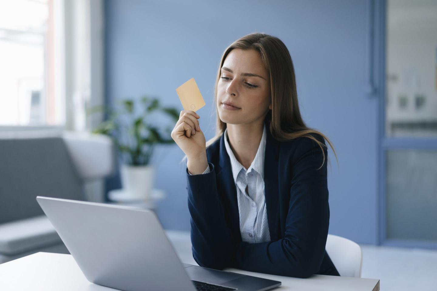 Young woman dressed in a suit completing an online payment with her credit card