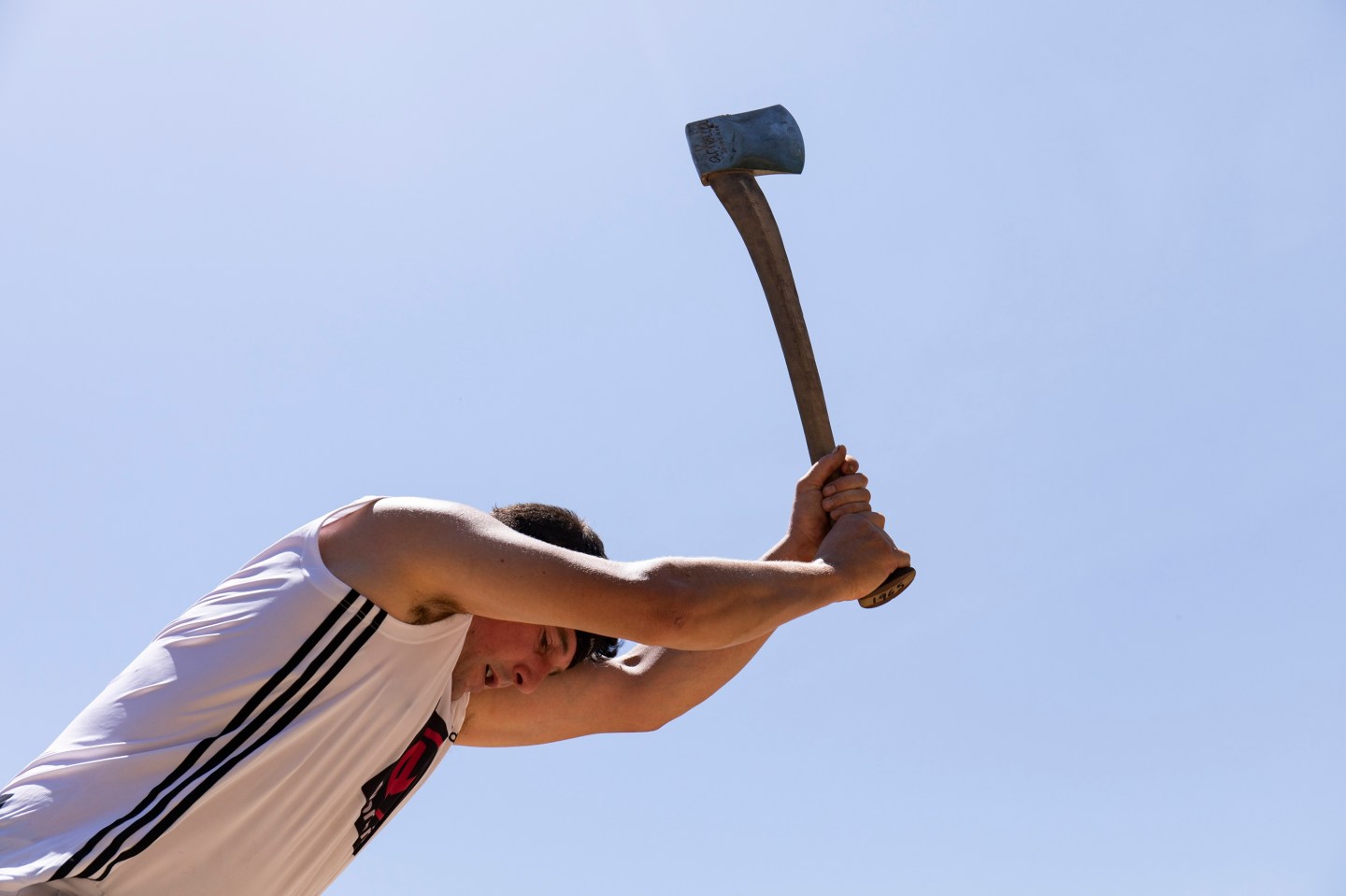 Photo: A man chopping wood with an axe.