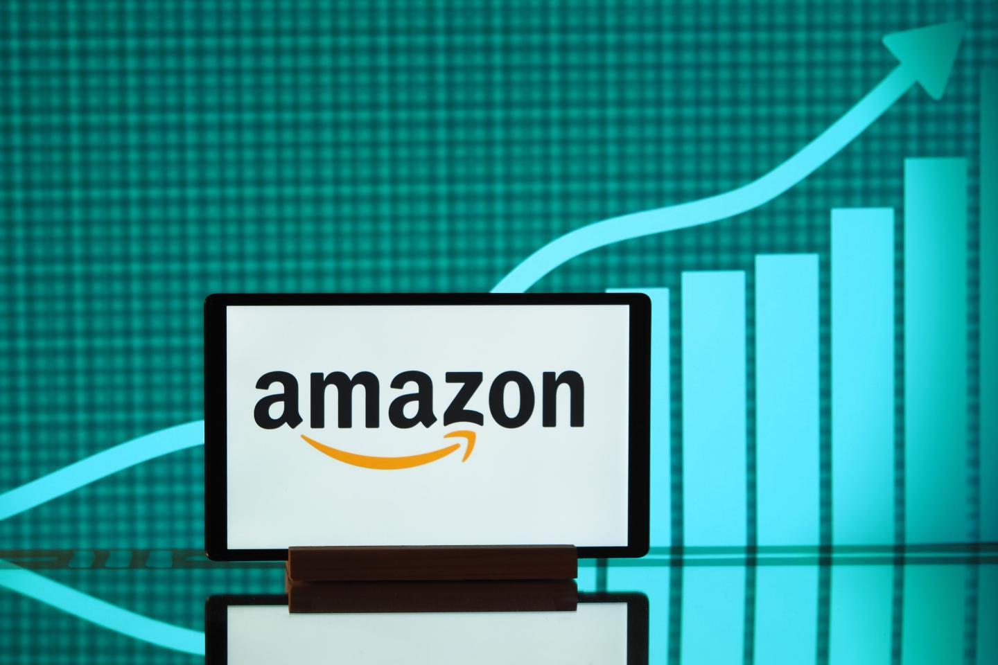 The Amazon logo seen displayed on a smartphone screen with a graph in the background.