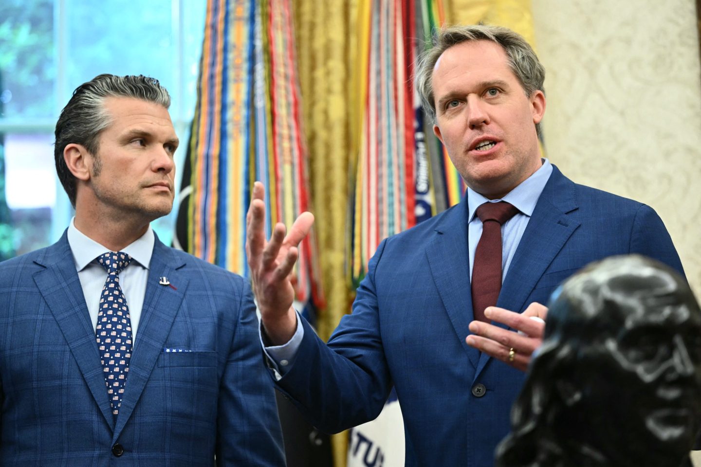 US Secretary of Defense Pete Hegseth, left, listens to Jacob DeWitte, CEO of Oklo, speak as US President Donald Trump signs executive orders in the Oval Office of the White House in Washington, DC, on May 23, 2025.