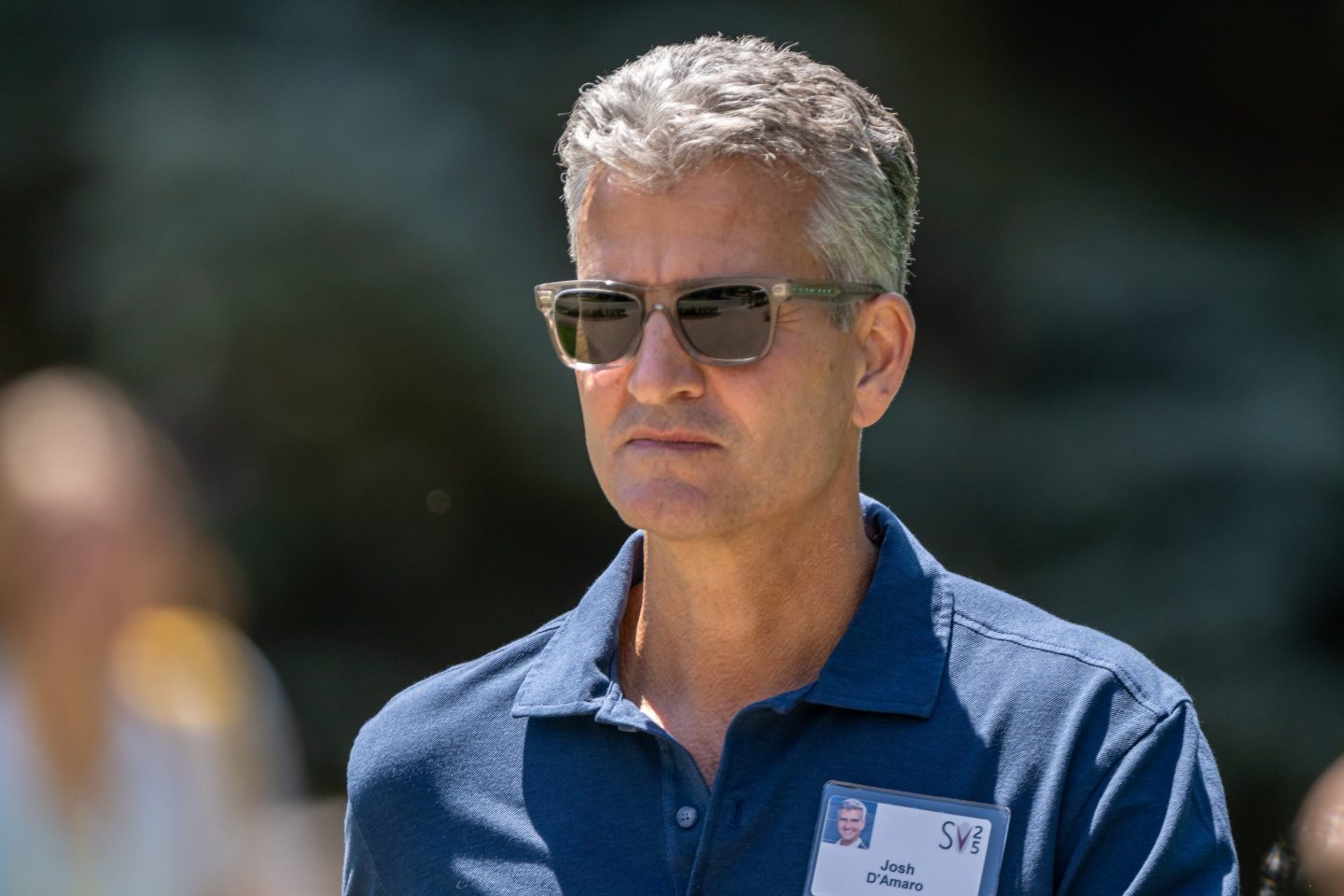 Man wearing sunglasses and a collared shirt.