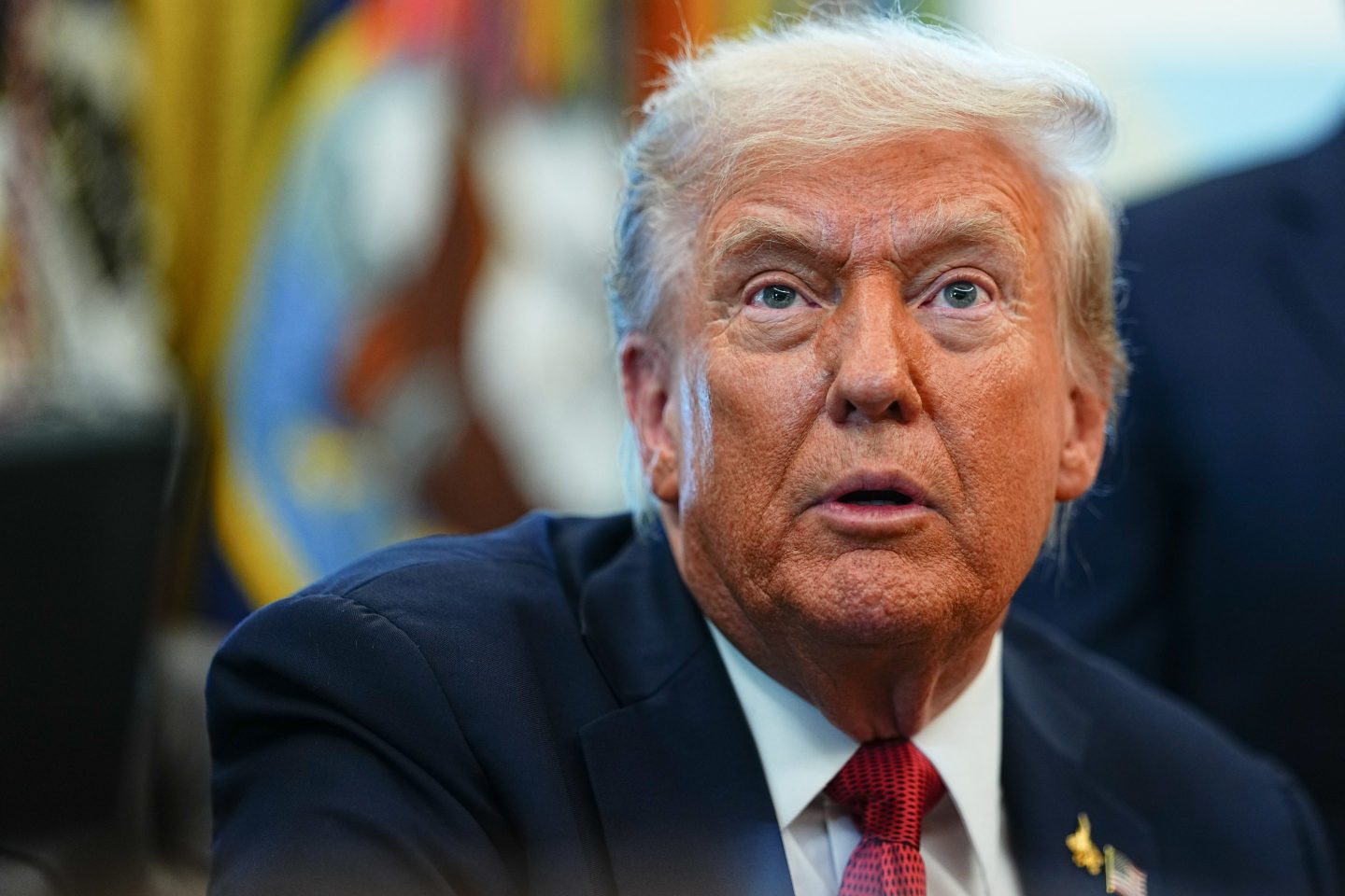 Closeup of US President Donald Trump as he speaks in the Oval Office of the White House.