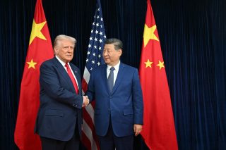 US President Donald Trump (L) and China's President Xi Jinping shake hands as they arrive for talks at the Gimhae Air Base, located next to the Gimhae International Airport in Busan on October 30, 2025.