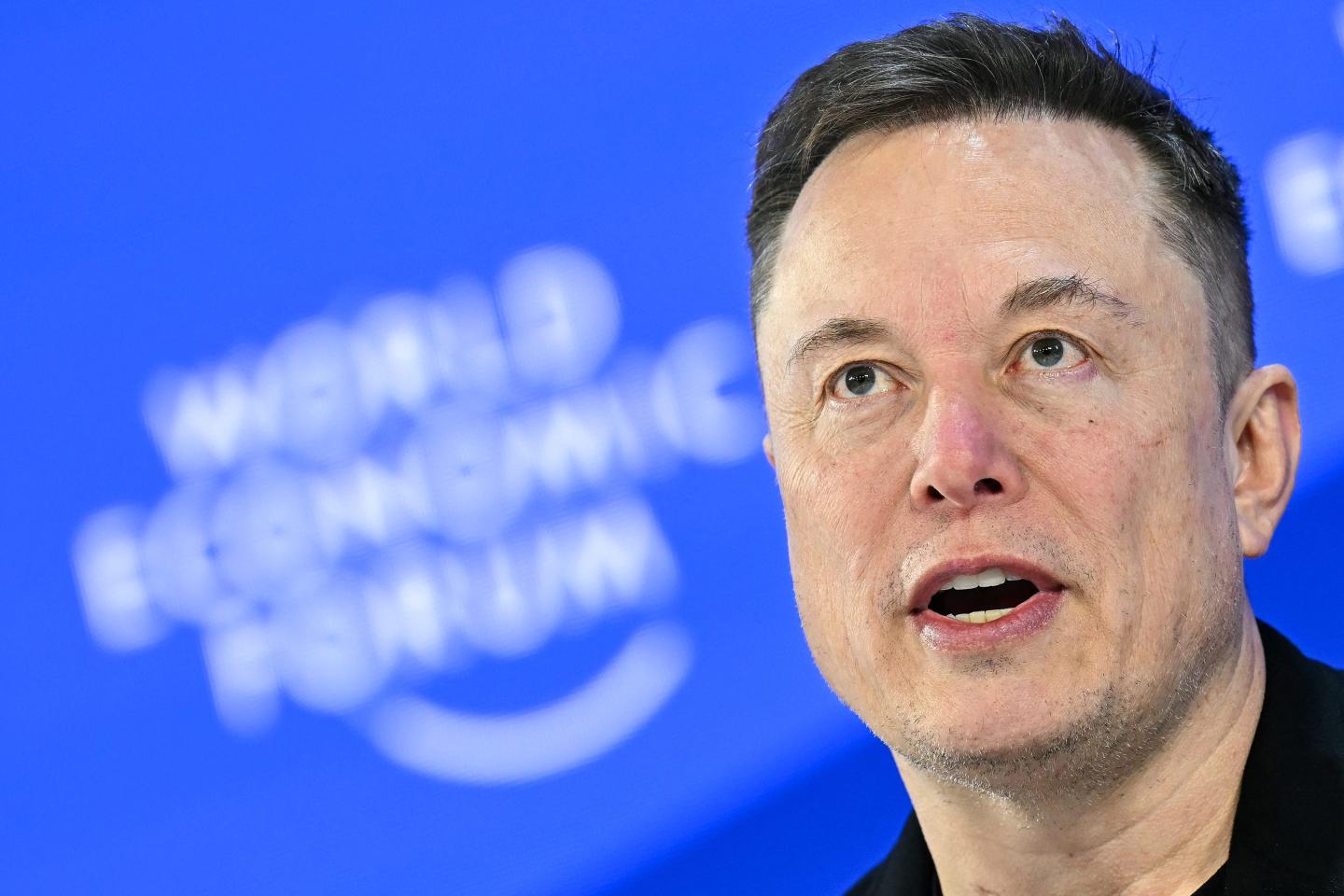 Man speaking with a blue background.