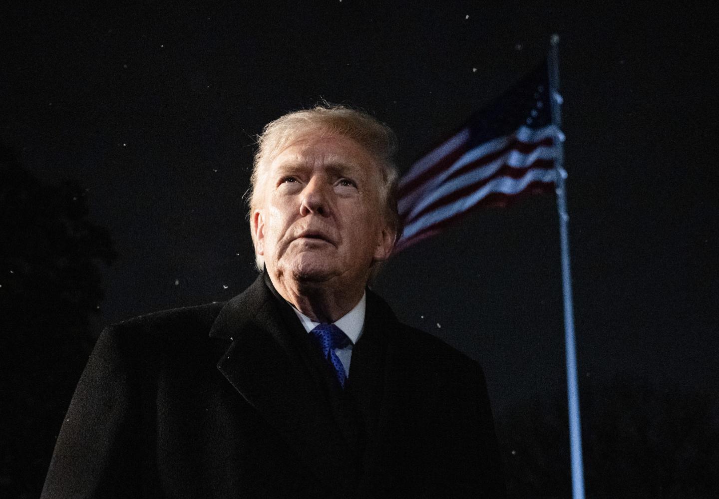 President Donald Trump pictured in front of a waving American flag.