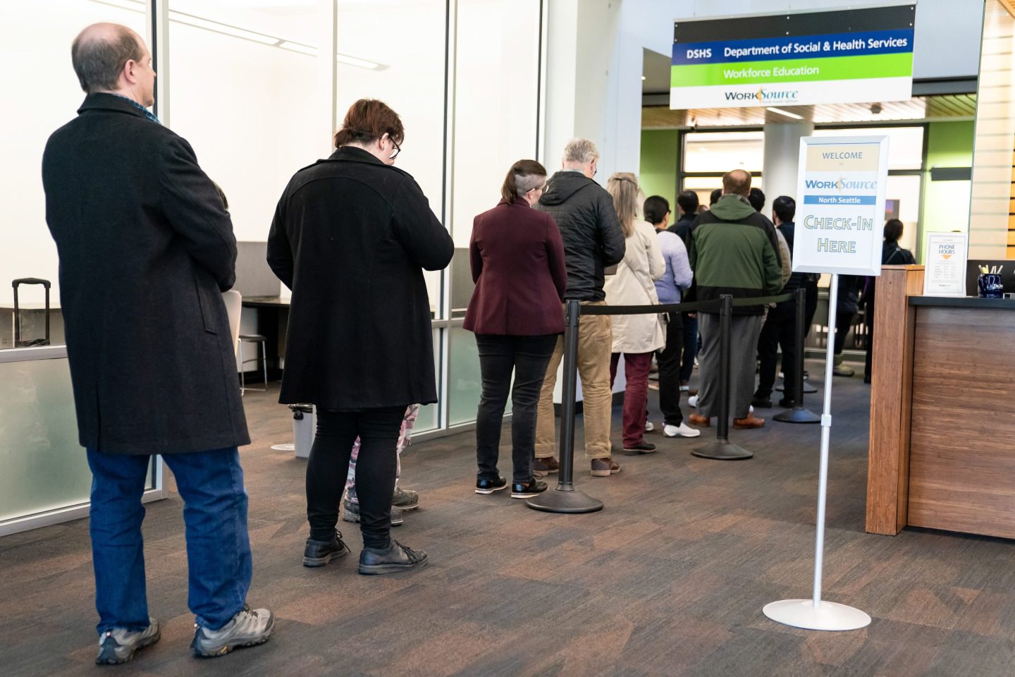 People stand in a line at a job fair.