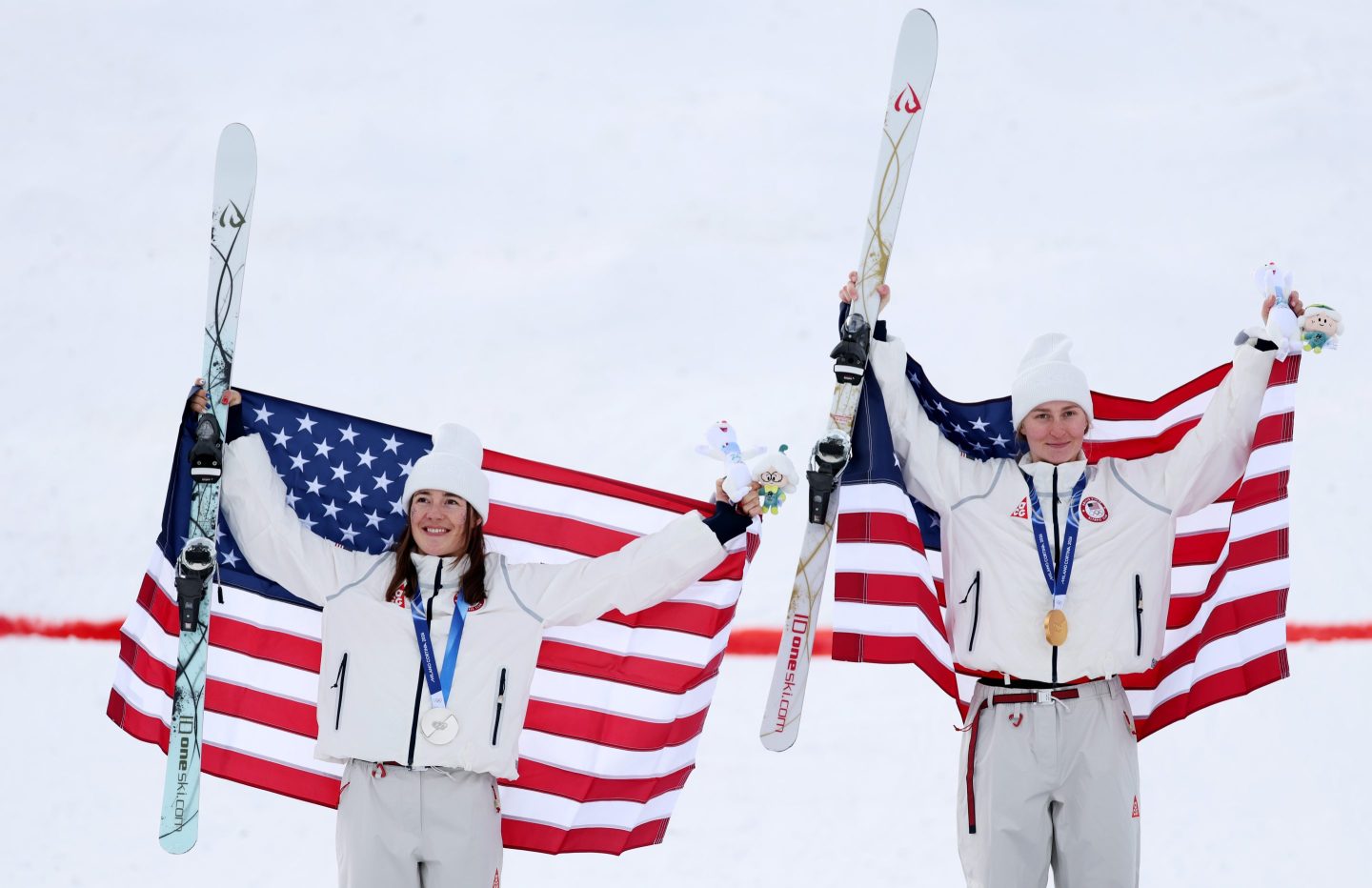 Lemley and Kauf pose for photos while holding their skis and American flags.