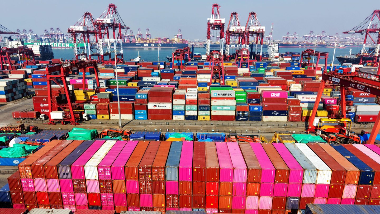 Multicolored shipping containers stacked up at a port in China.