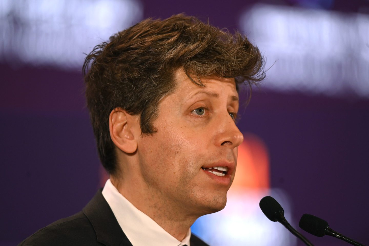 Sam Altman speaks into a microphone