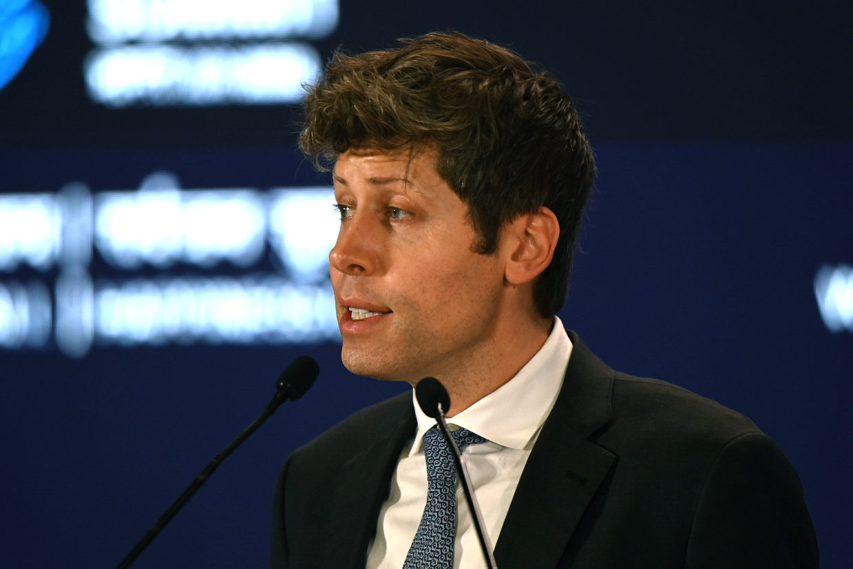 OpenAI CEO Sam Altman speaking in front of a microphone.