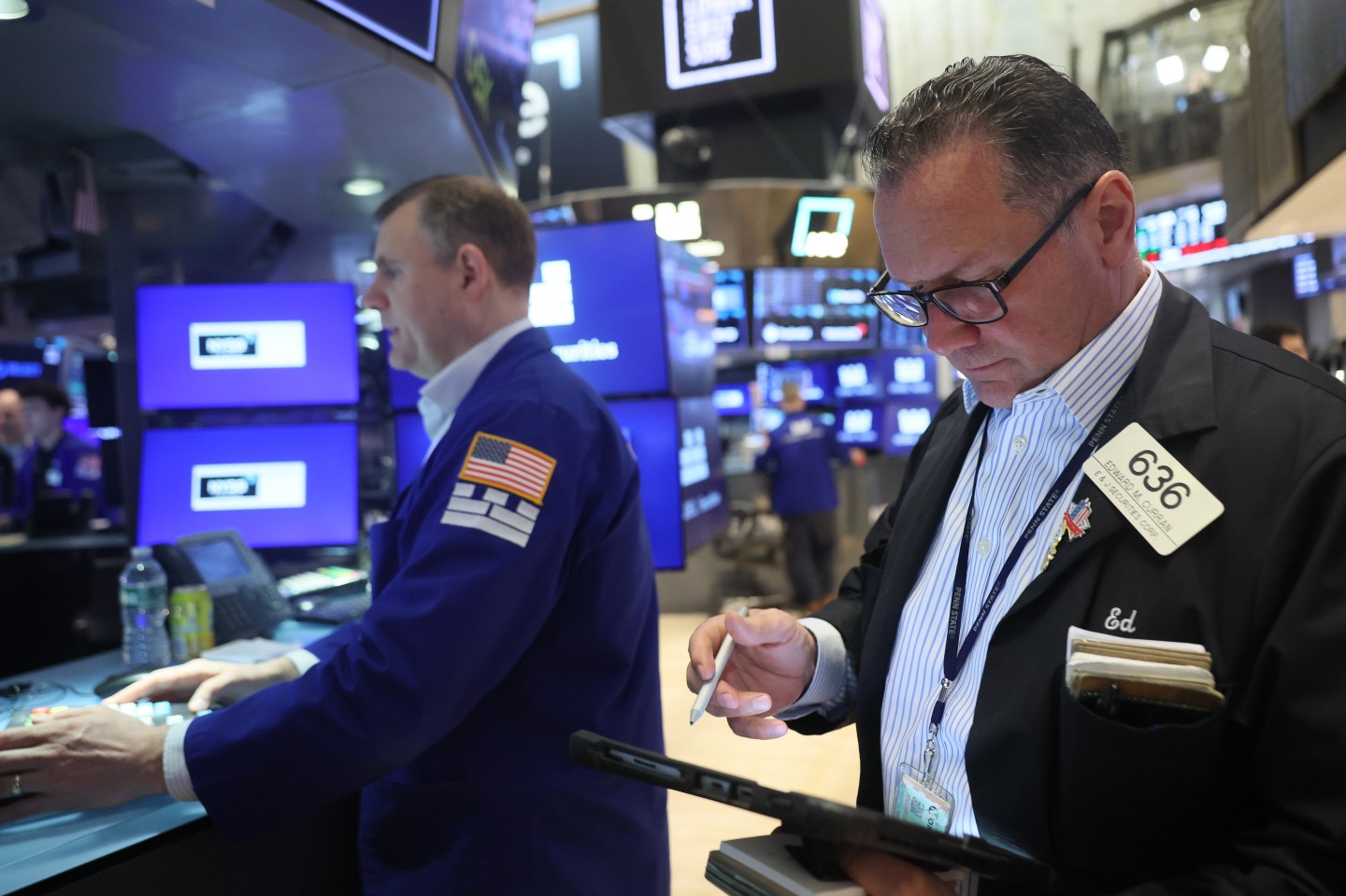 Traders stand at the New York Stock Exchange
