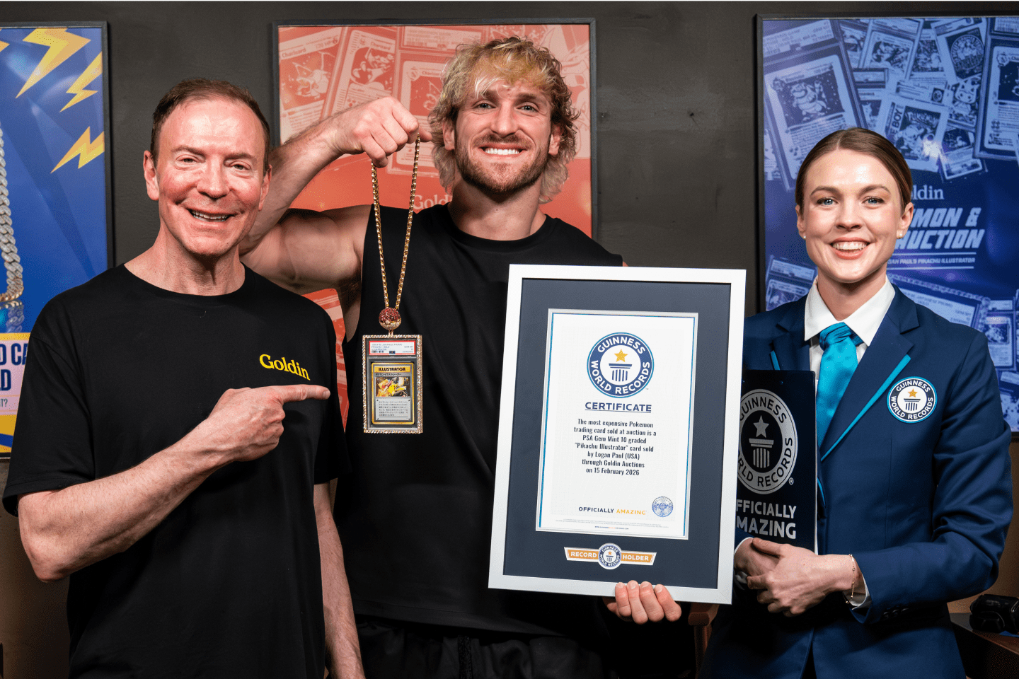 Ken Goldin, Logan Paul, and a Guinness World Record woman stand with Paul's Pokemon card
