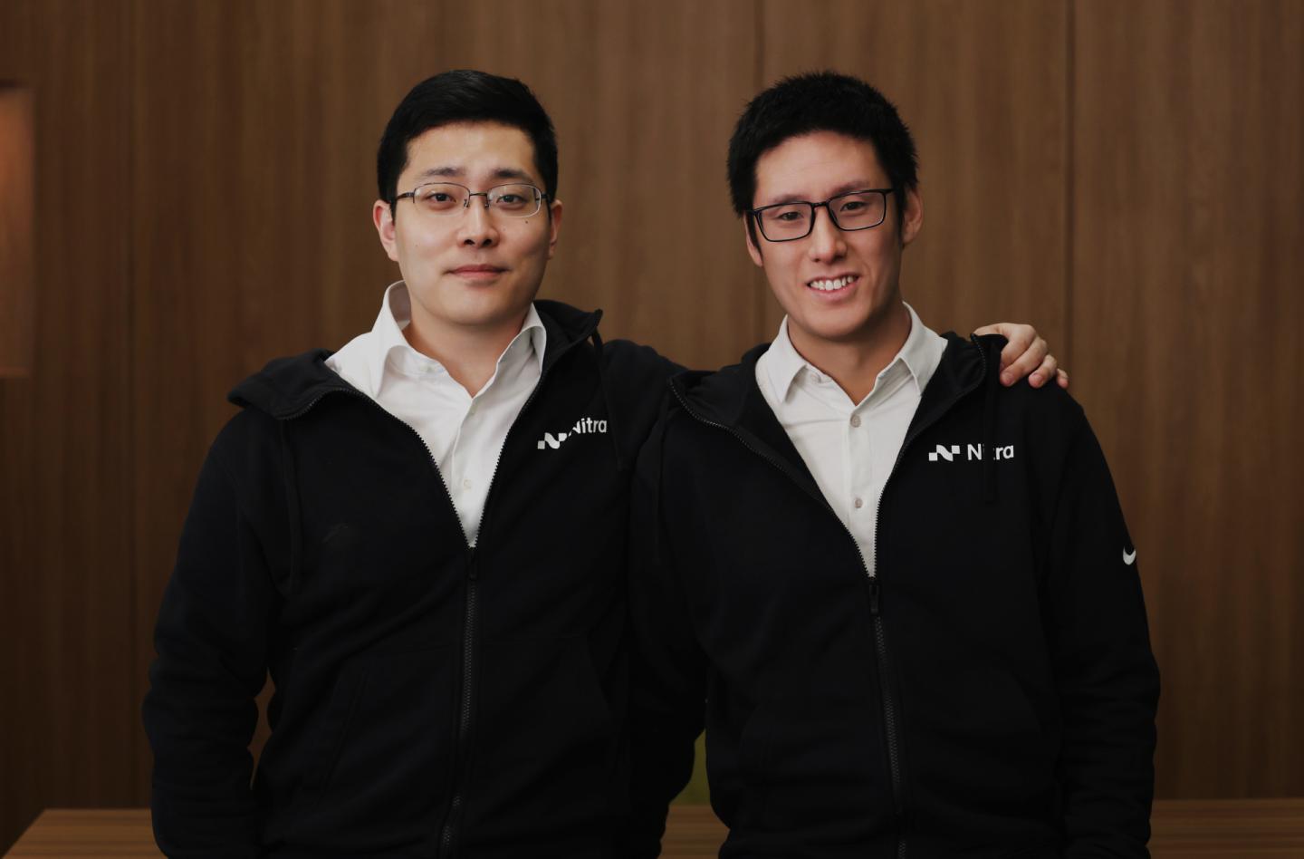 Two men in white button downs under black zip ups.
