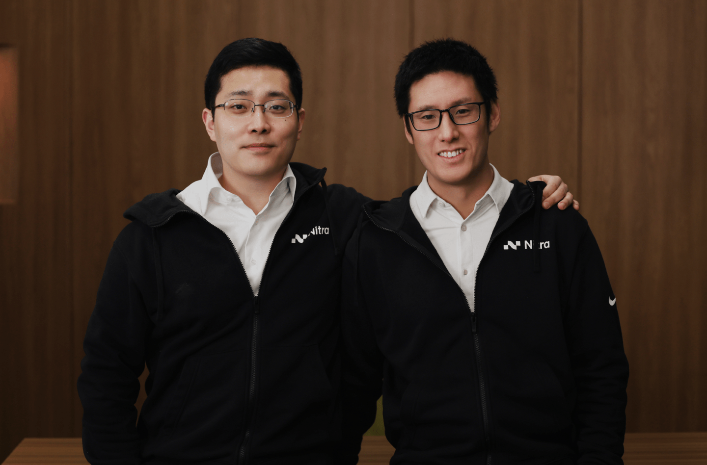 Two men in white button downs under black zip ups.