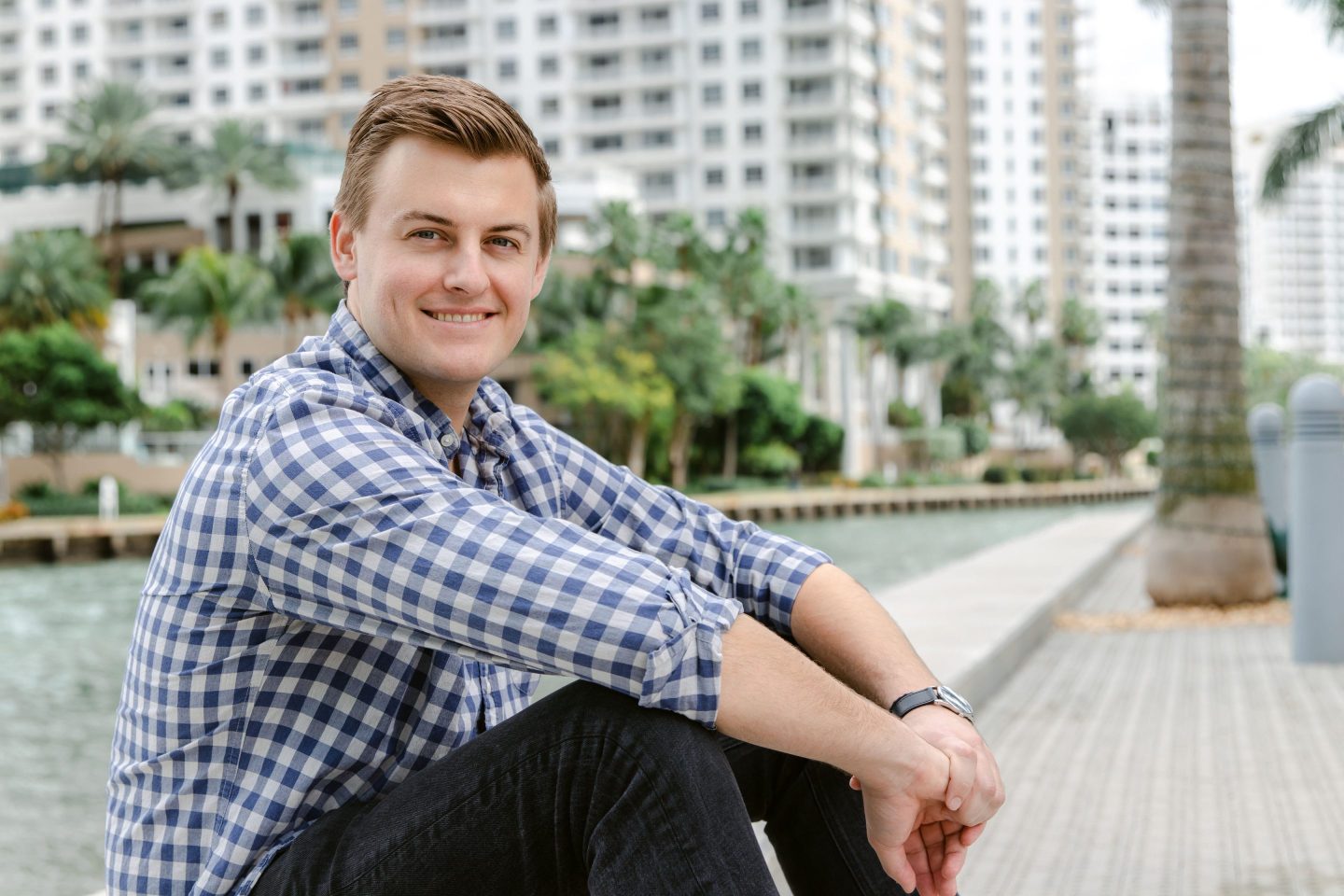man poses with arms crossed over legs