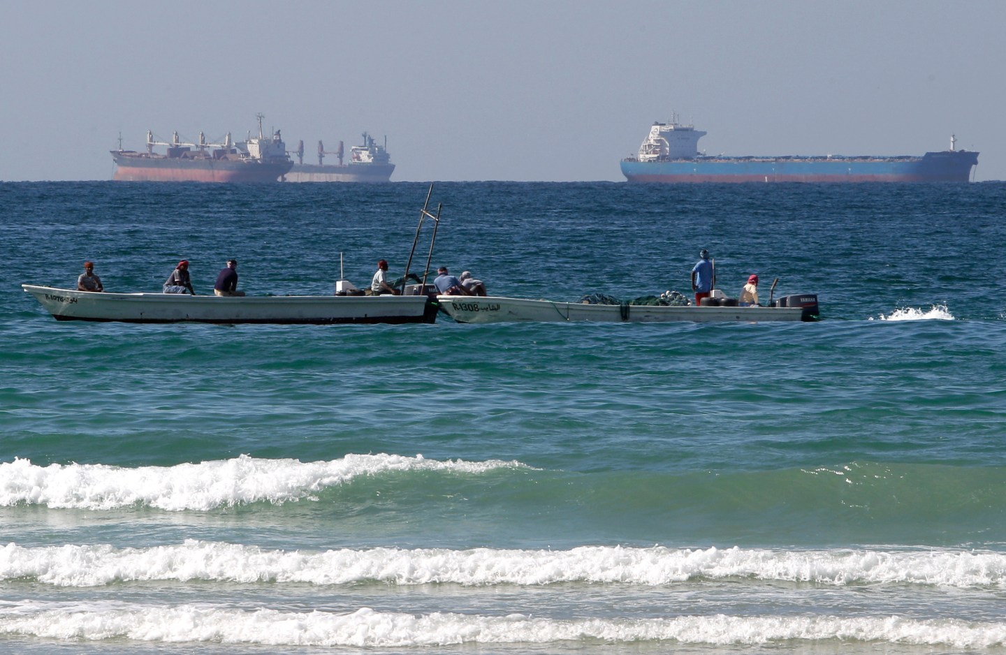 FILE - Fishermen work in front of oil tankers south of the Strait of Hormuz Jan. 19, 2012, offshore the town of Ras Al Khaimah in United Arab Emirates. (AP Photo/Kamran Jebreili, File)