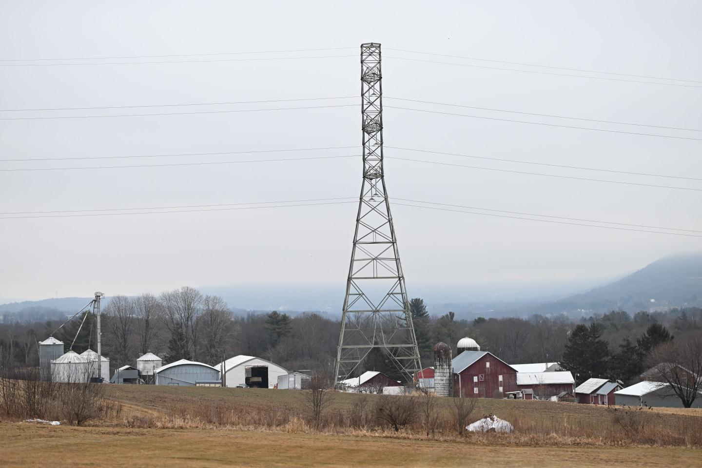 A 235-kilovolt power line towers over farm buildings near where the local power utility plans to build a 500-kilovolt power line on towers as tall as 240 feet, March 4, 2026, in Sugarloaf, Pa.