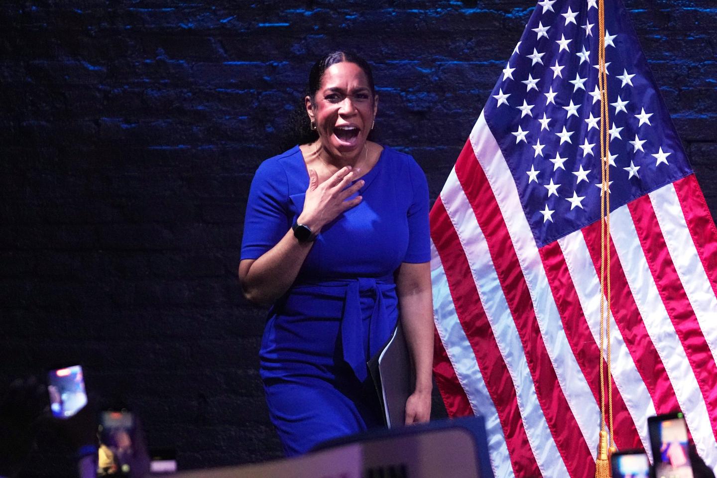 Woman in blue in front of the American flag
